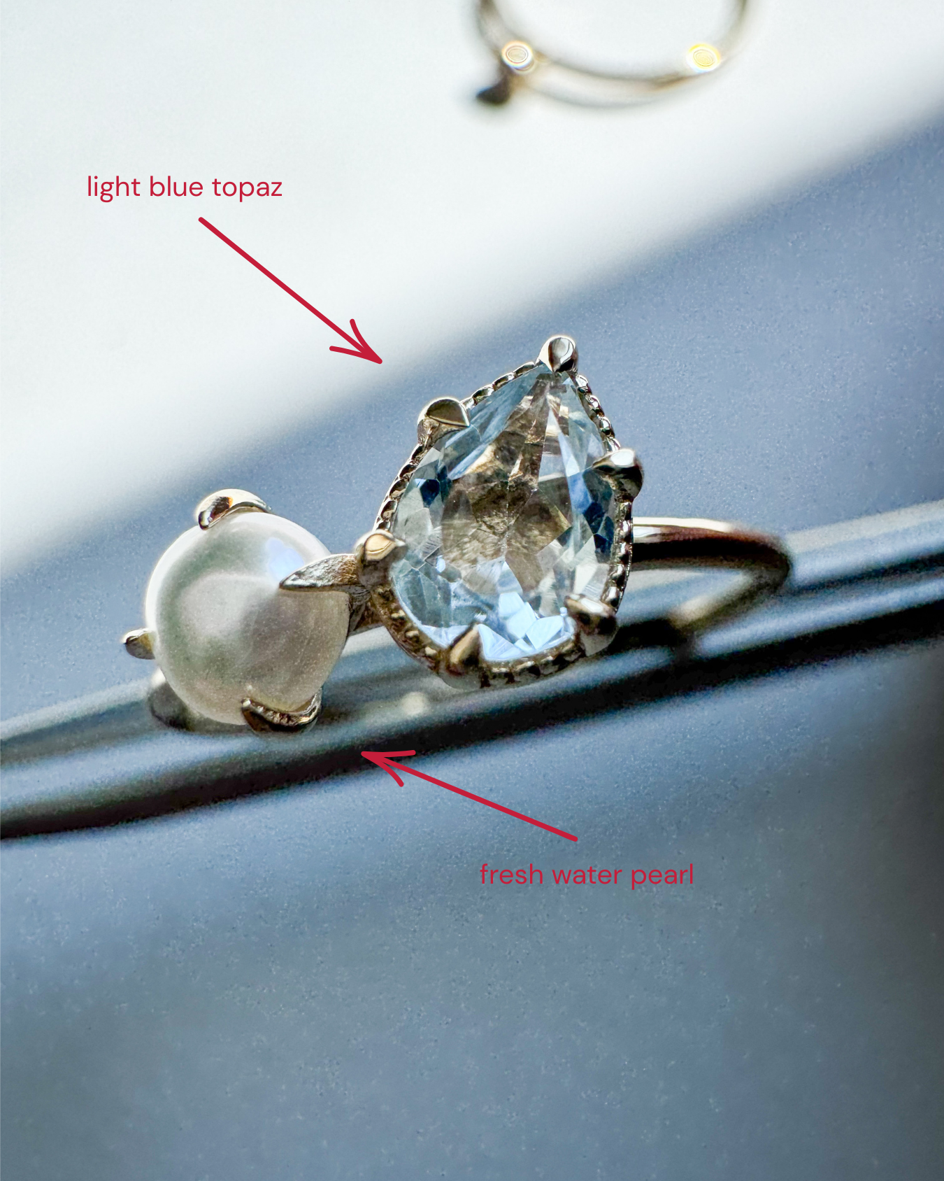 Gold-plated sterling silver ring set with a faceted blue topaz and a round freshwater pearl.
