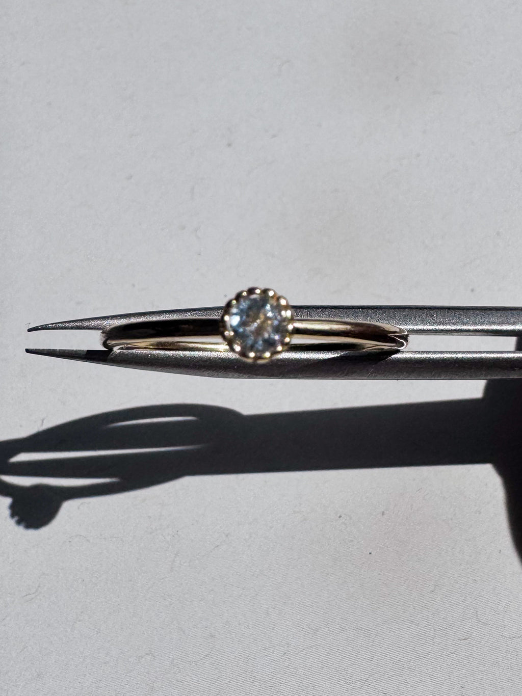 18ct gold-plated sterling silver ring with a single light blue  topaz in a crown setting