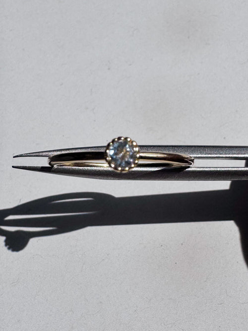 18ct gold-plated sterling silver ring with a single light blue  topaz in a crown setting