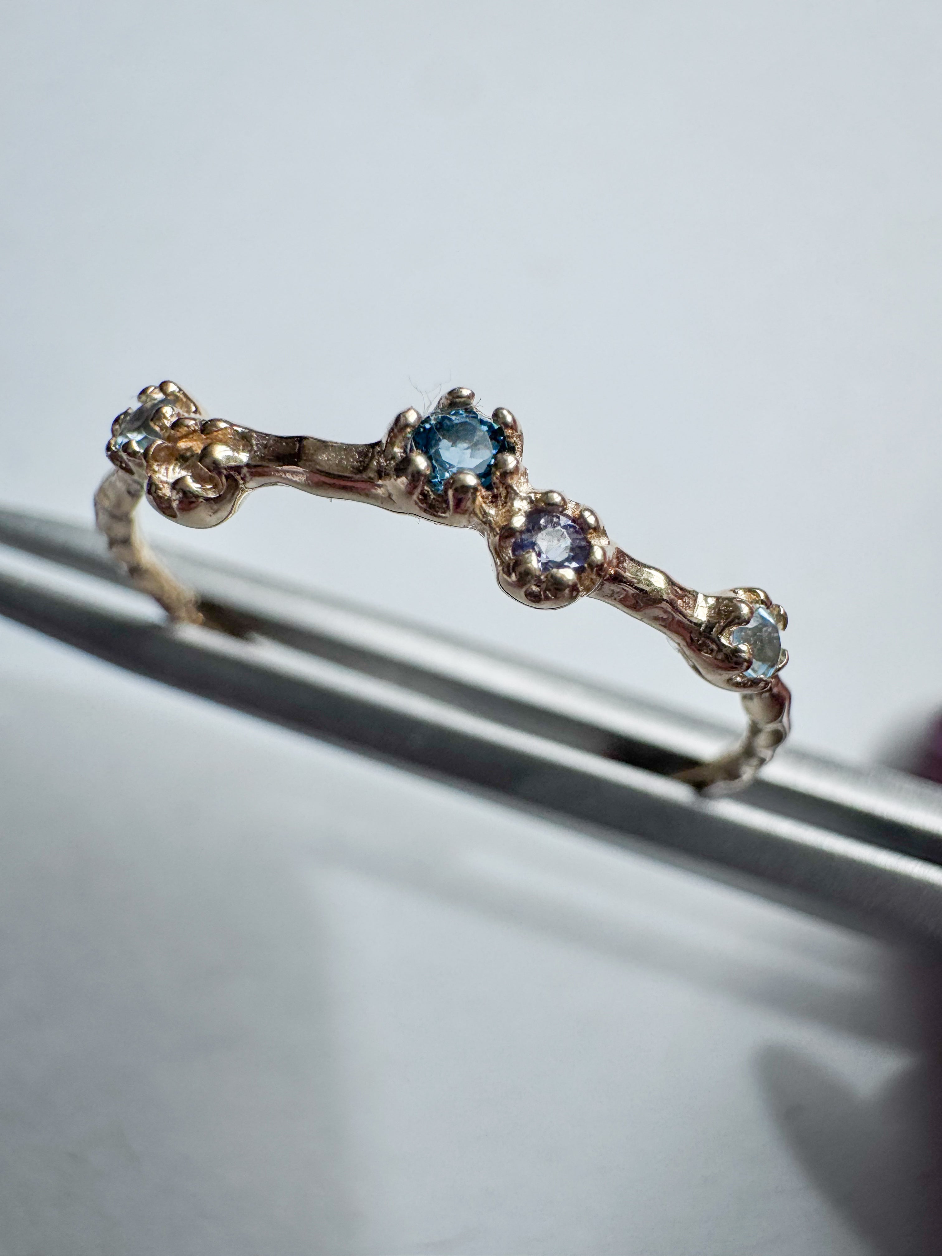 Gold-plated sterling silver ring set with a brilliant-cut blue topaz and a round faceted iolite.