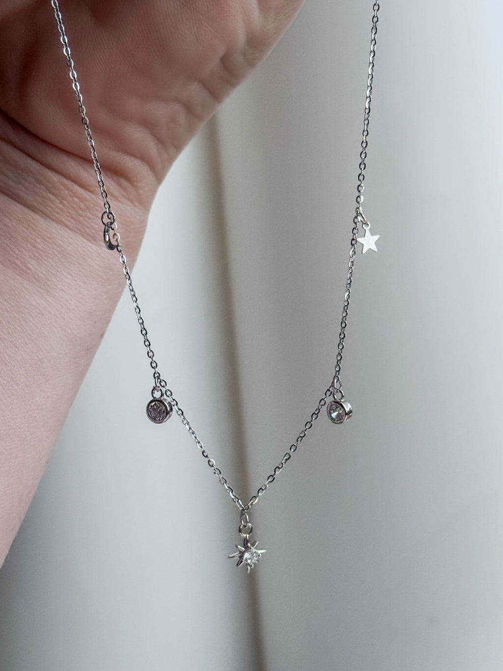 Rhodium-plated sterling silver necklace with a cubic zirconia starburst pendant and star charms